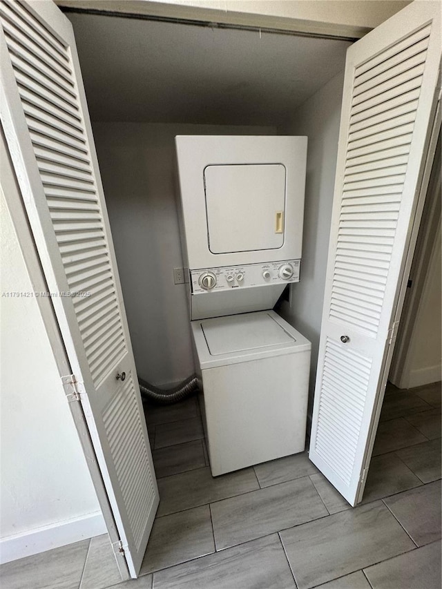 9851 Sandalfoot Blvd Unit 208, Boca Raton, FL 33428 - laundry area featuring estacked washer and dryer, baseboards, and wood tiled floors