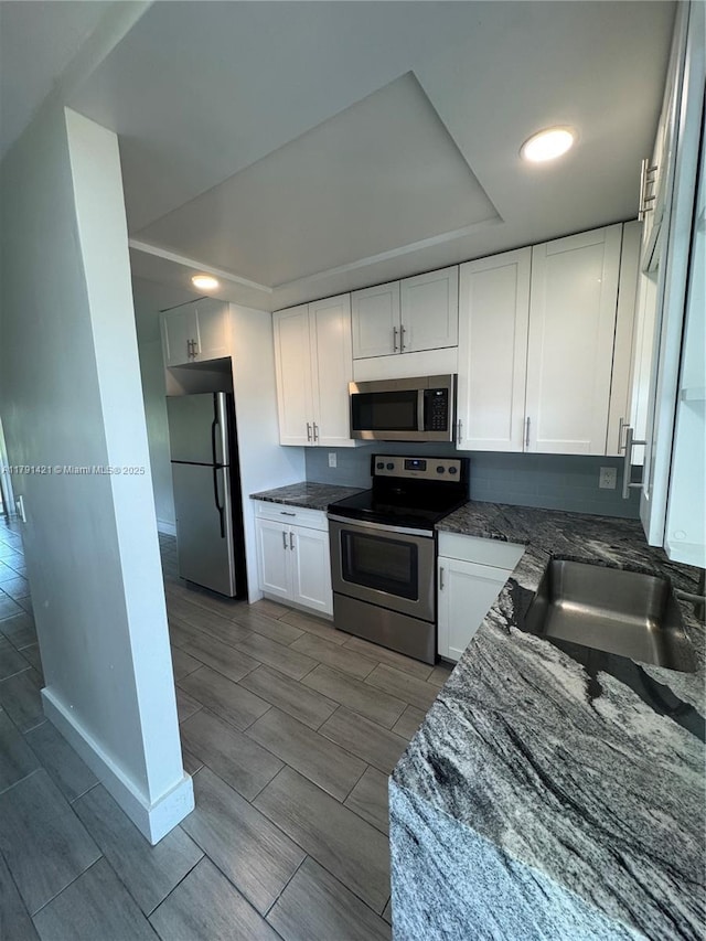 9851 Sandalfoot Blvd Unit 208, Boca Raton, FL 33428 - kitchen featuring appliances with stainless steel finishes, a sink, wood finish floors, and white cabinetry