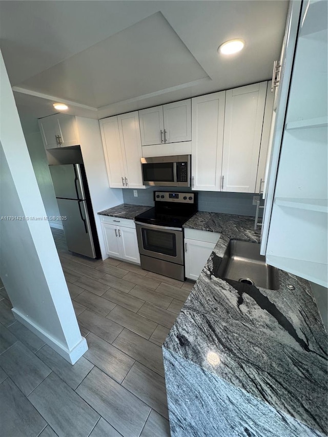 9851 Sandalfoot Blvd Unit 208, Boca Raton, FL 33428 - kitchen featuring appliances with stainless steel finishes, a sink, white cabinetry, and wood tiled floors