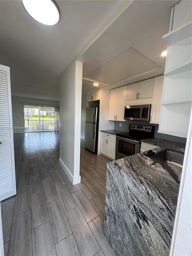 9851 Sandalfoot Blvd Unit 208, Boca Raton, FL 33428 - kitchen with stainless steel appliances, open shelves, a sink, white cabinets, and wood tiled floors