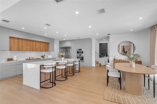 1509 SW 15th St, Miami, FL 33145 - kitchen featuring modern cabinets, light wood-style floors, stainless steel appliances, and visible vents