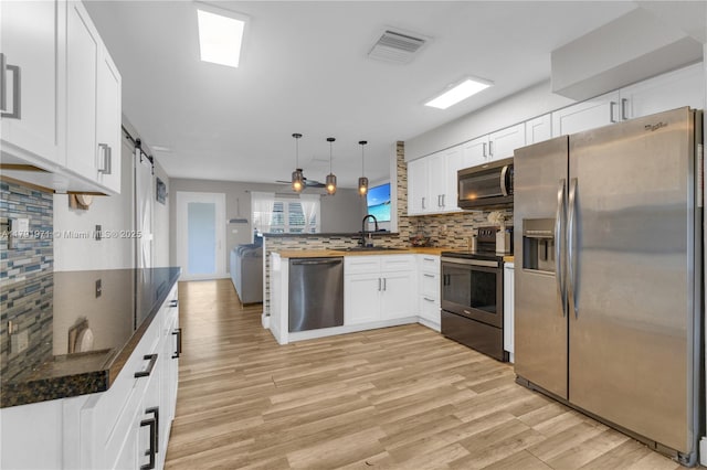 4649 SW 28th Ave, Dania Beach, FL 33312 - kitchen with backsplash, visible vents, stainless steel microwave, dark stone counters, and white cabinetry