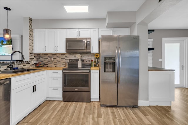4649 SW 28th Ave, Dania Beach, FL 33312 - kitchen featuring visible vents, a peninsula, light wood-type flooring, tasteful backsplash, and stainless steel appliances