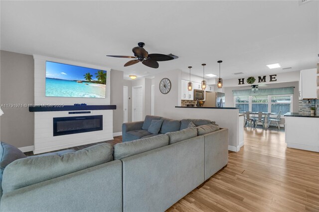 4649 SW 28th Ave, Dania Beach, FL 33312 - kitchen with a ceiling fan, appliances with stainless steel finishes, tasteful backsplash, light wood-style floors, and white cabinetry