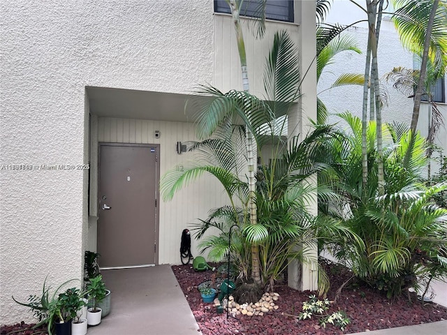 property entrance with stucco siding