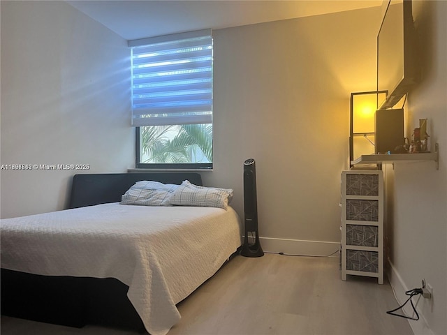 bedroom with baseboards and wood finished floors