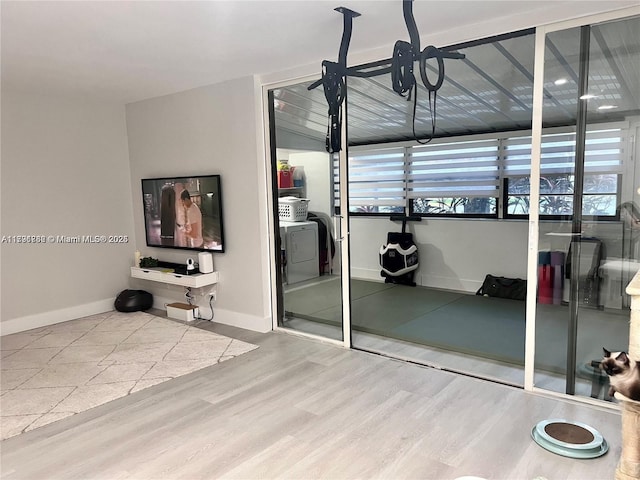 unfurnished bedroom featuring multiple windows, wood finished floors, baseboards, and a closet