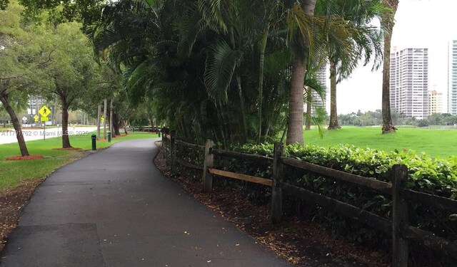 view of property's community with a lawn and fence