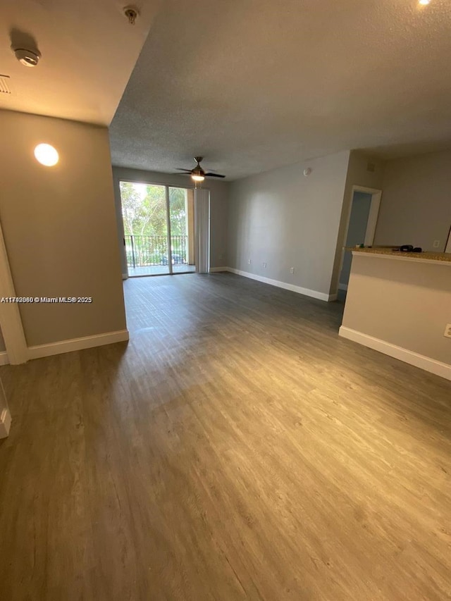 2351 W Preserve Way Unit 205, Miramar, FL 33025 - unfurnished living room with a ceiling fan, a textured ceiling, wood finished floors, and baseboards
