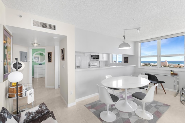 dining room with visible vents, a textured ceiling, baseboards, and light tile patterned flooring