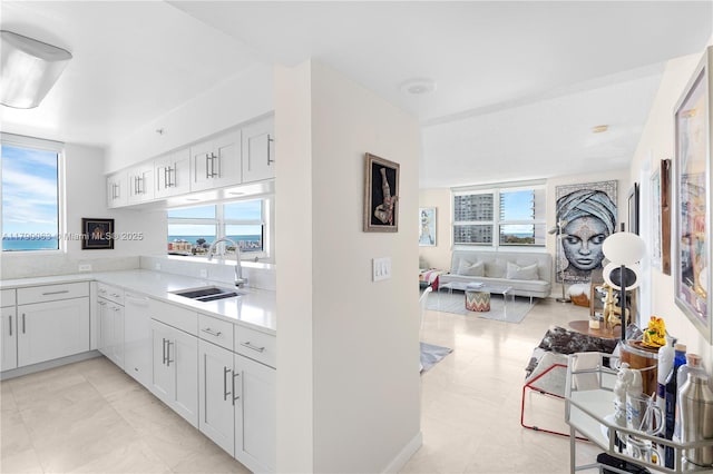 650 W Ave Unit 2102, Miami Beach, FL 33139 - kitchen featuring healthy amount of natural light, open floor plan, light countertops, and white cabinets