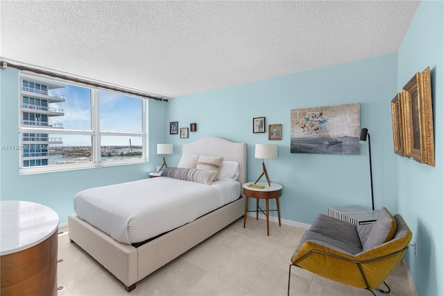 bedroom featuring a textured ceiling and baseboards