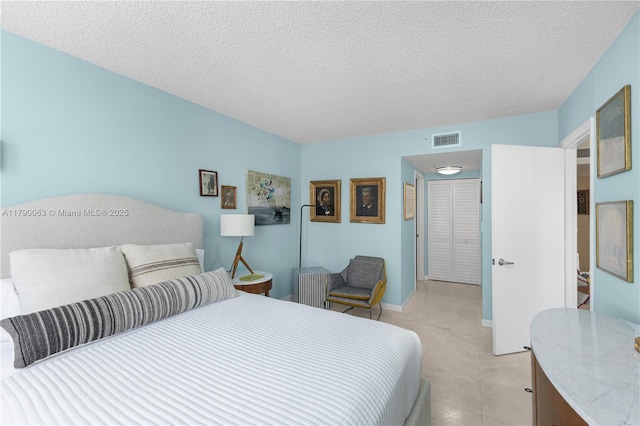 bedroom with visible vents and a textured ceiling