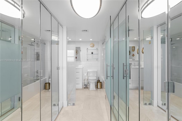 bathroom featuring visible vents, a stall shower, toilet, and tile walls