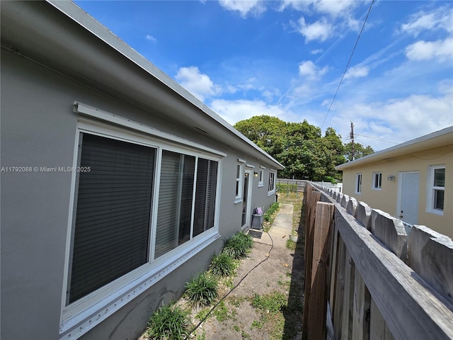 2281 NE 173rd St, North Miami Beach, FL 33160 - view of side of property with fence, central AC, and stucco siding
