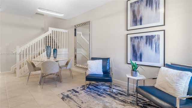 sitting room featuring tile patterned floors, stairway, and baseboards