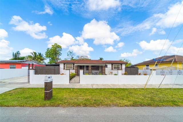 single story home with a front lawn, a fenced front yard, and a gate