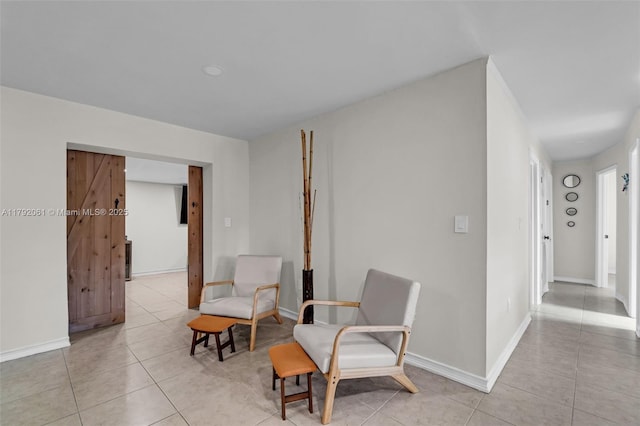living area featuring baseboards and light tile patterned floors