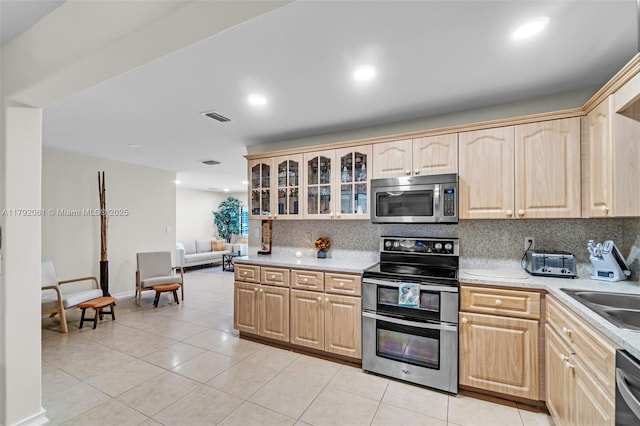 kitchen featuring visible vents, backsplash, stainless steel appliances, and light brown cabinets