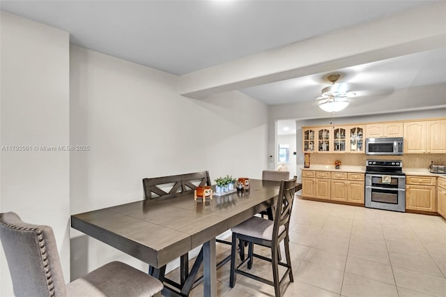 dining space with light tile patterned floors and ceiling fan