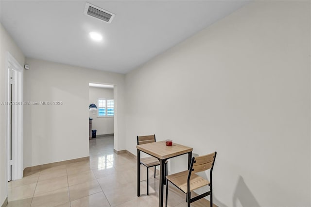 corridor with light tile patterned flooring, visible vents, and baseboards