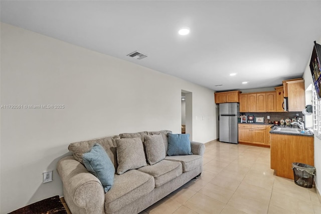 living room with light tile patterned floors, recessed lighting, and visible vents