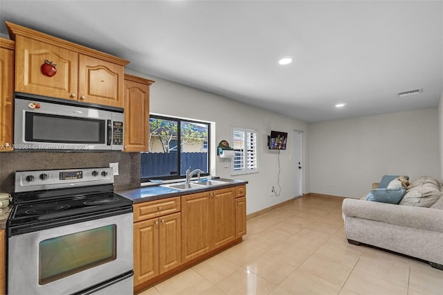kitchen featuring a sink, appliances with stainless steel finishes, visible vents, dark countertops, and open floor plan