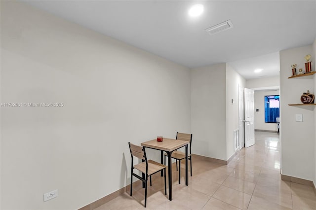 dining space featuring baseboards, visible vents, and light tile patterned floors