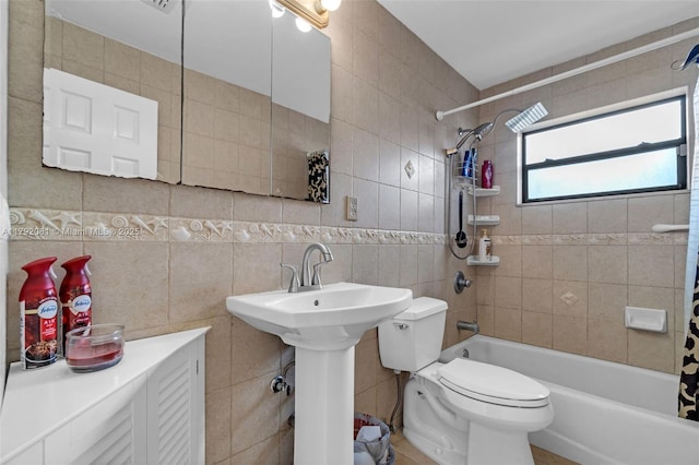 full bath with tile walls, shower / bathtub combination with curtain, toilet, and a sink