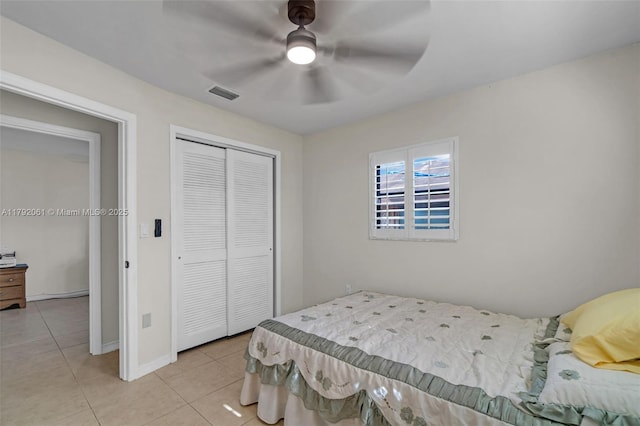 bedroom featuring light tile patterned flooring, visible vents, a ceiling fan, and a closet