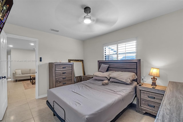 bedroom with light tile patterned floors, visible vents, a ceiling fan, and baseboards