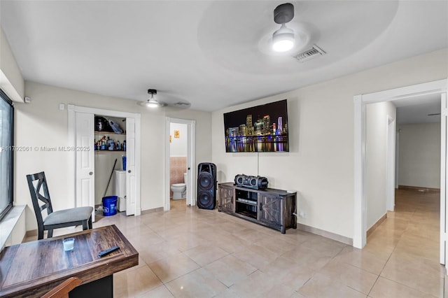 living area with light tile patterned floors, ceiling fan, baseboards, and visible vents