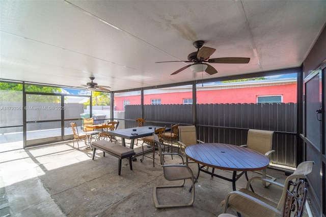 sunroom with a wealth of natural light, ceiling fan, and outdoor dining area