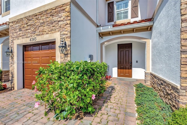property entrance featuring stone siding and stucco siding