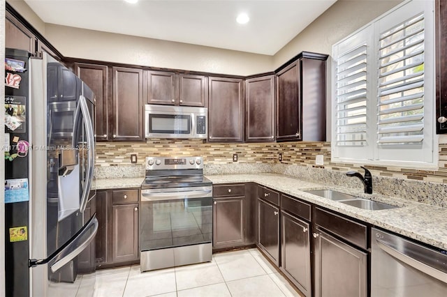 kitchen with dark brown cabinetry, light tile patterned flooring, stainless steel appliances, and decorative backsplash