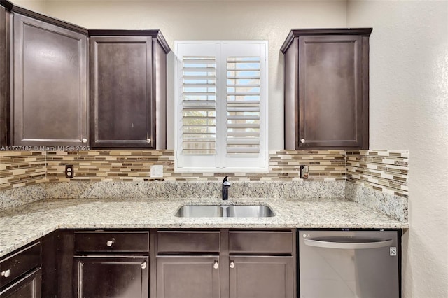 kitchen with stainless steel dishwasher, a sink, and dark brown cabinets