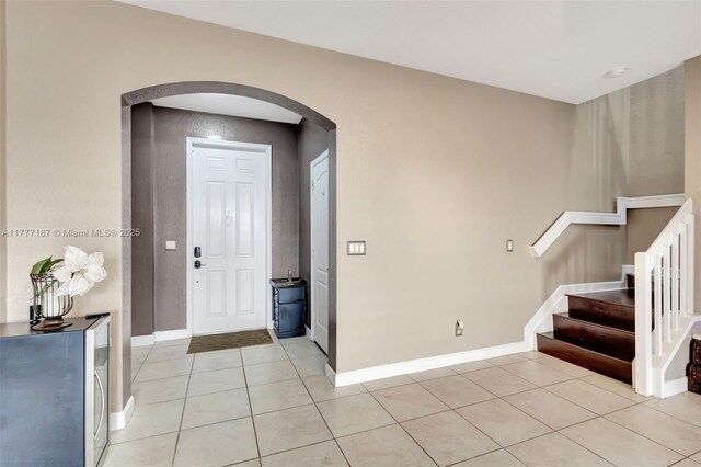 4343 Chalmers Ln, West Palm Beach, FL 33417 - foyer entrance featuring arched walkways, light tile patterned floors, and stairway