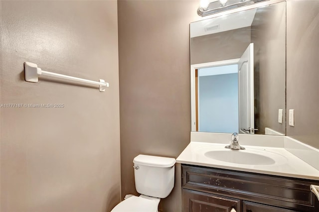 half bath featuring toilet and vanity