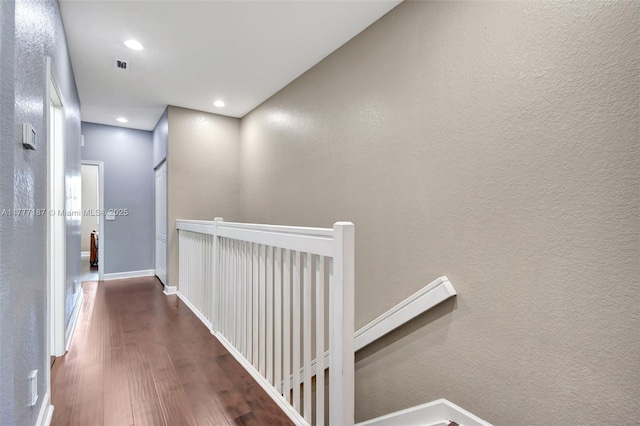 hall featuring recessed lighting, an upstairs landing, visible vents, baseboards, and wood finished floors