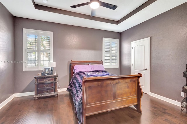 bedroom with baseboards, wood finished floors, and a textured wall