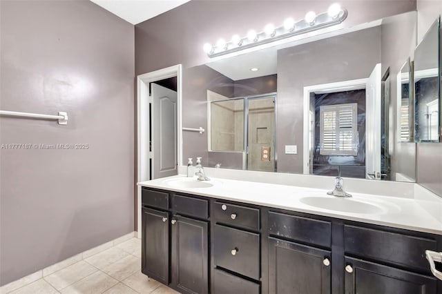bathroom featuring double vanity, a sink, a shower stall, and tile patterned floors