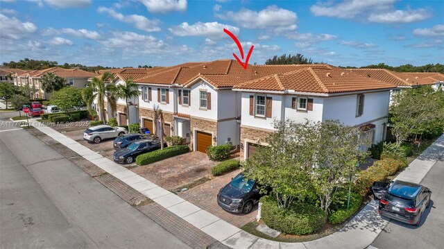 4343 Chalmers Ln, West Palm Beach, FL 33417 - view of front of property with stone siding, a garage, a tile roof, stucco siding, and decorative driveway