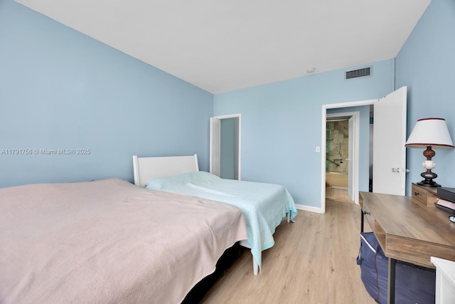 bedroom with visible vents, light wood-style flooring, and baseboards