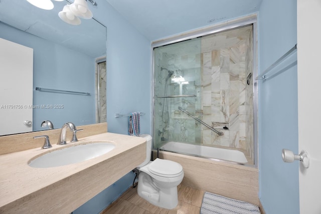 bathroom with bath / shower combo with glass door, toilet, and vanity
