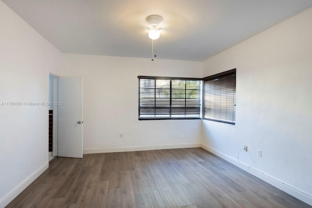 empty room with baseboards and wood finished floors