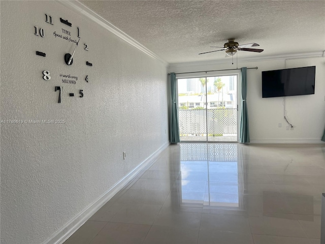 tiled empty room with ornamental molding, ceiling fan, a textured wall, baseboards, and a textured ceiling