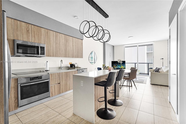 3900 Biscayne Blvd Unit S-920, Miami, FL 33137 - kitchen featuring stainless steel appliances, modern cabinets, light brown cabinets, a breakfast bar area, and light tile patterned floors