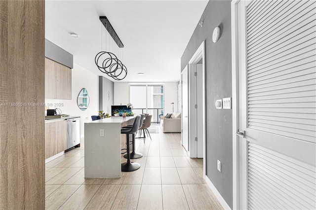 3900 Biscayne Blvd Unit S-920, Miami, FL 33137 - kitchen featuring modern cabinets, a breakfast bar, stainless steel dishwasher, light countertops, and a kitchen island
