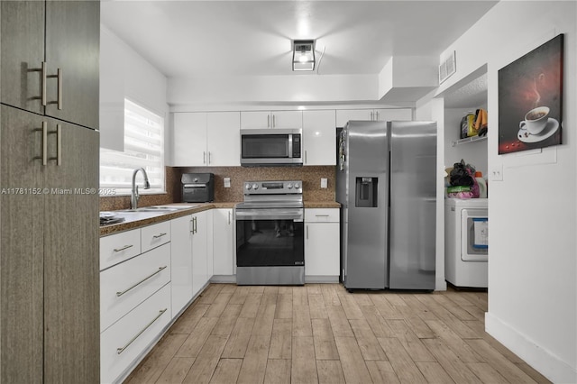 1131 SW 104th Ct, Miami, FL 33174 - kitchen featuring stainless steel appliances, a sink, white cabinetry, visible vents, and washer / clothes dryer