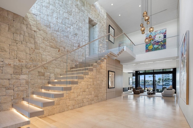 staircase with a high ceiling and wood finished floors